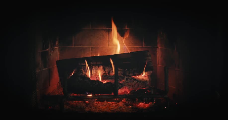 A fire burning in a fireplace in a dark room