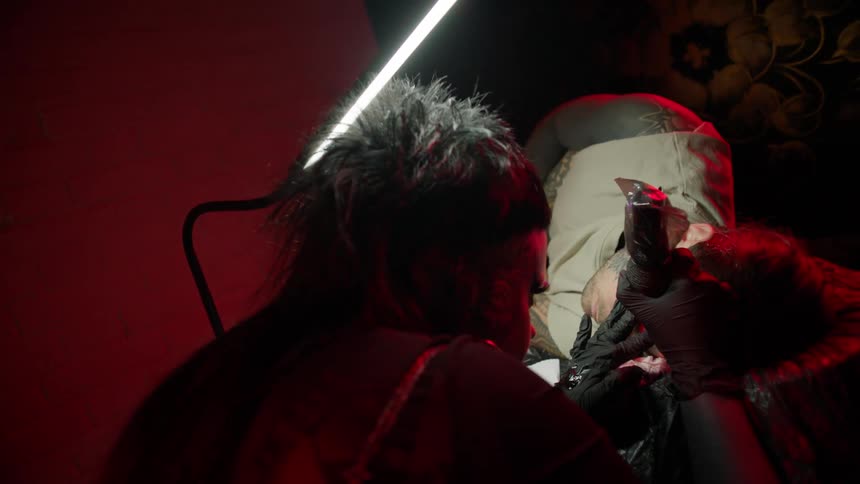 A clip of a person drawing a tattoo on another person