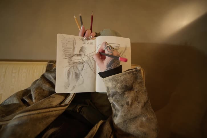 Tattooed artist drawing on a sketchbook