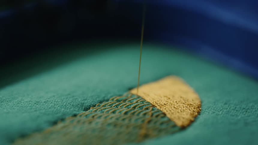 The sewing machine sews a label on the fabric