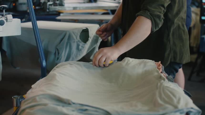 Workers screen printing tshirts on a warehouse
