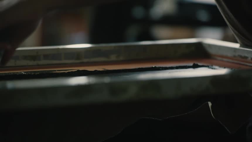 Closeup of a persons hands applying texture paint to a small manufacturing tool