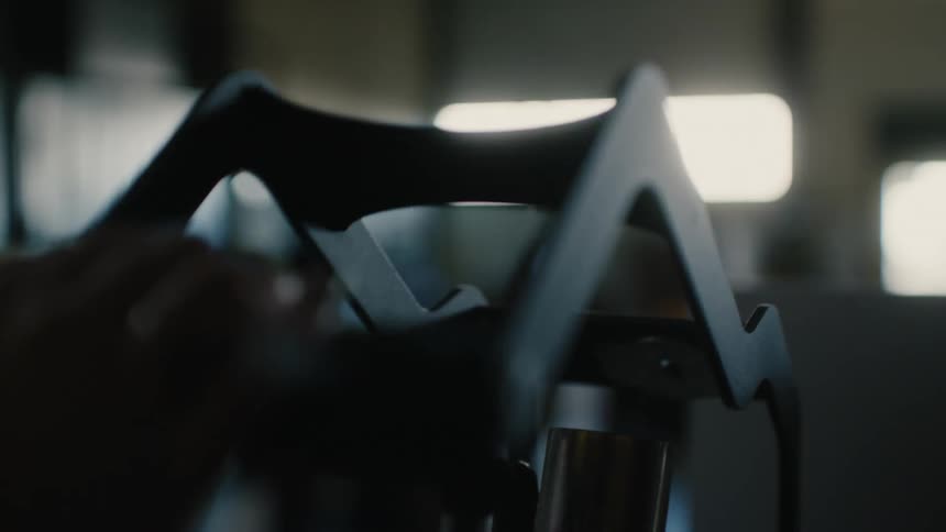 Closeup of a mans hand pressing on a metallic object