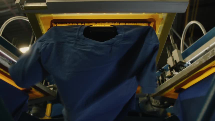 Machine pressing ink onto blue tshirts