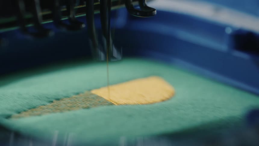 Closeup of a sewing machine stitching with yellow thread