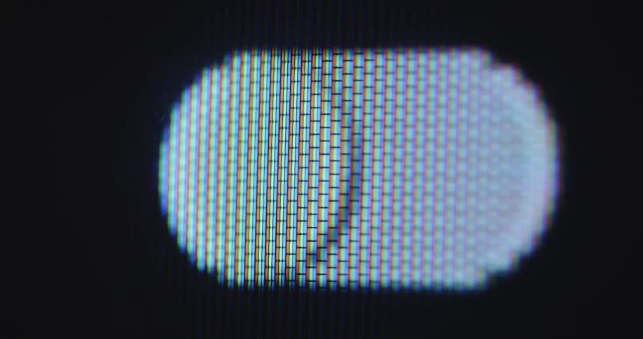 A female person presses the touch screen on the dark monitor with black background to start or stop a process or feature of her smartphone or other display device