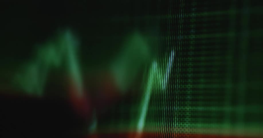 Dynamic handheld close-up of animated trend line graph moving up and down from positive to negative price performance on a dark pixelated screen with green grid in the background