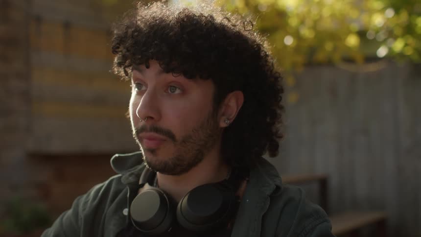 Portrait of a man with headphones around his shoulders talking