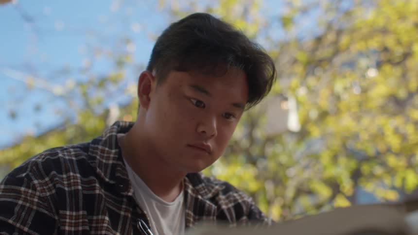Portrait of an asian man writing something with a pen