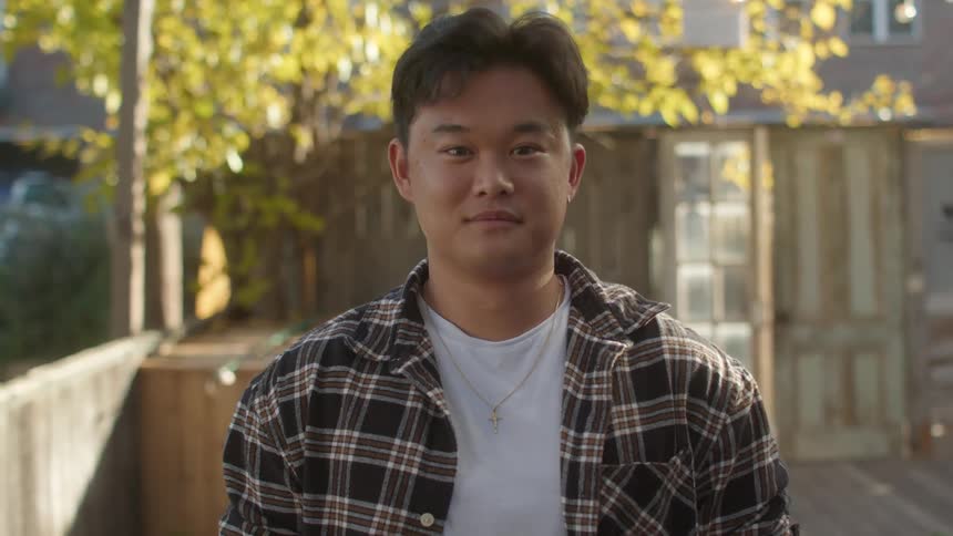 A face of a young asian boy with necklace and plaid shirt