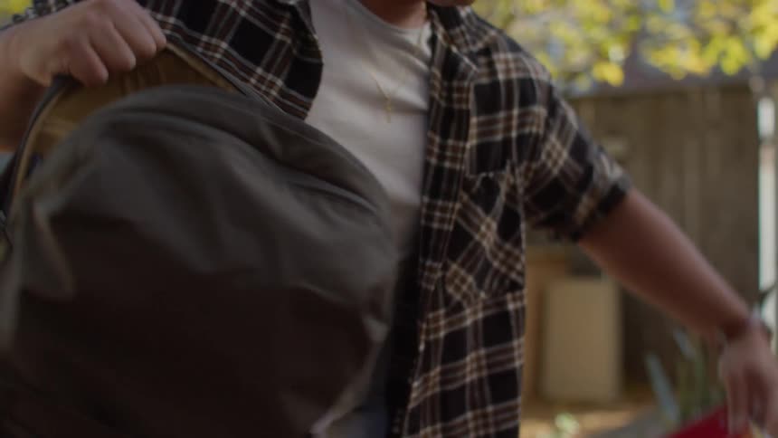 Teenage student pulls out books and notebooks from his backpack and begins to work
