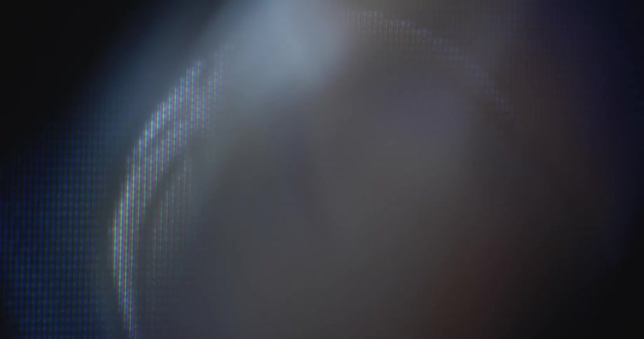 Dynamic hand-held closeup macro shot of a digitized basketball animation rolling or spinning in the air on a computer screen as it warps and fades with distortion and retro RGB pixels