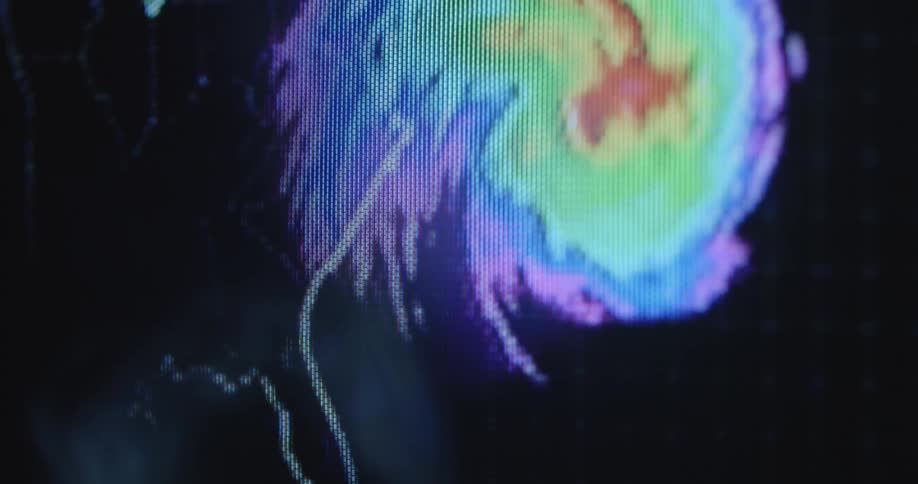 An animated hurricane spins and moves along the US east coast on a digitized radar screen with RGB pixels during the weather report of the daily news on television