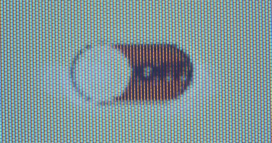 Extreme macro closeup of a finger pressing and releasing a slide button on a bright screen with RGB pixels and a white background switching between the green on setting and the red off position