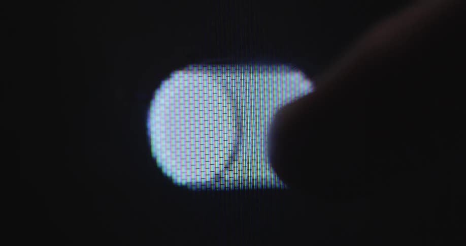 A person uses a touchscreen device such as a smartphone or computer touch display with black background to toggle a virtual switch back and forth with the finger of his right hand