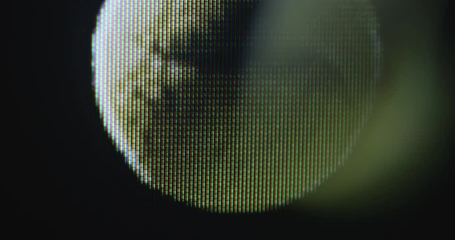 Extreme closeup of a TV or television screen displaying a tennis ball animation in motion rotating in slow motion while flying at high speed with dynamic and hand-held camera movement