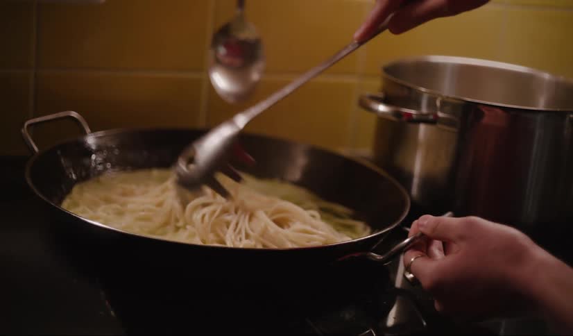 A person cooking a pasta in the kitchen