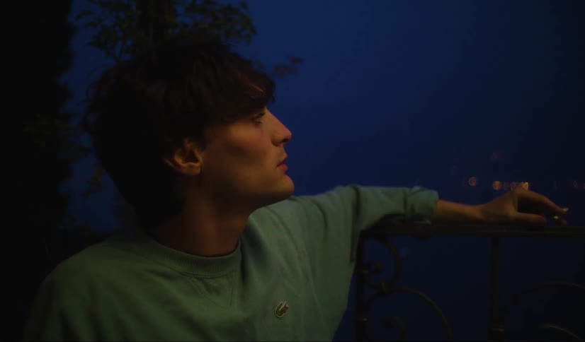 A man is smoking outside at night
