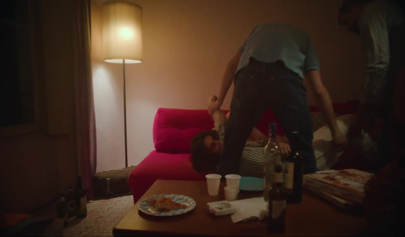 In the midst of a party with lots of drinking a passedout man is placed on a couch