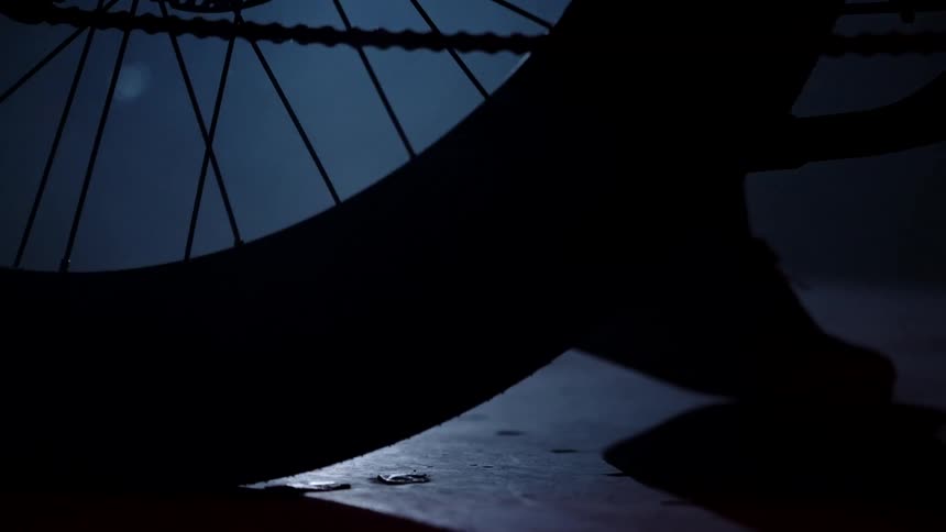 A closeup of the tire as a person rides the bicycle spinning smoothly on the road