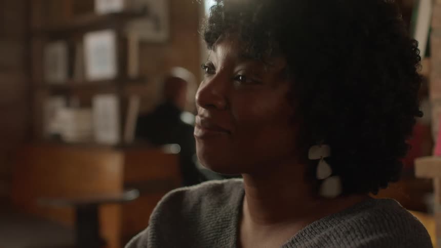 Woman sitting in a coffee shop talking to a friend