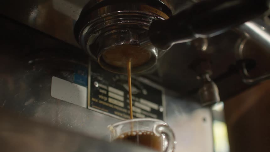 Coffee machine pouring an espresso into a glass cup