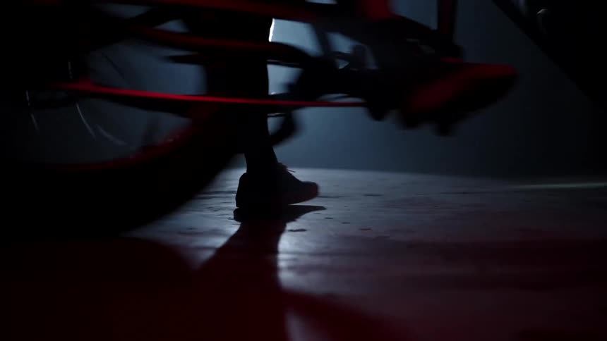 Silhouette of a person spinning on a bicycle