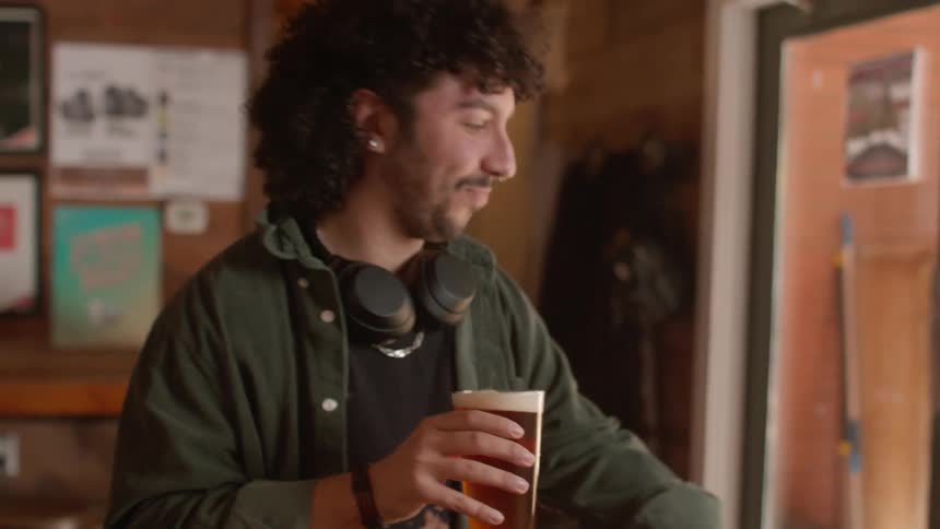 Pub bartender hands beer to customer who then walks outside