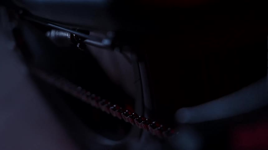 Close up of the gears of a bicycle under red lights