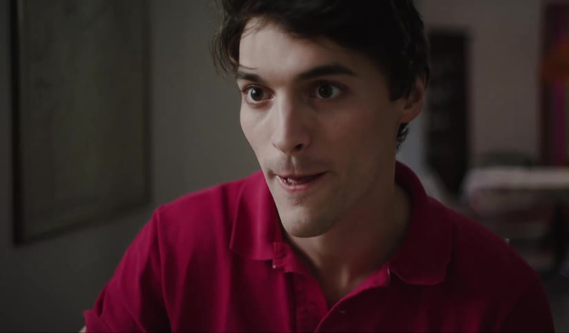 A man wearing a red polo tshirt casually enjoying spaghetti