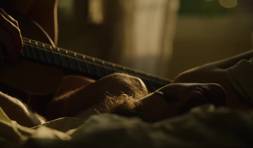 Man wakes up her girlfriend with a guitar in the bedroom