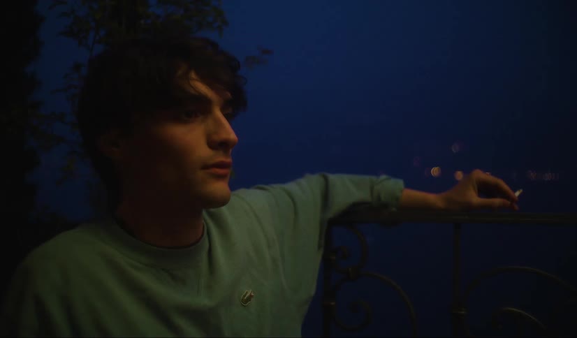 Man thinks as he sits on porch at night and smokes