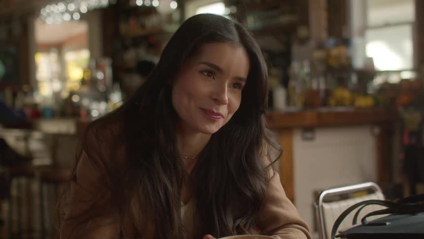 A woman is having coffee with someone and talking