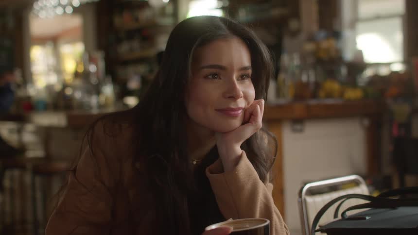 Woman listens to a friends while drinking coffee