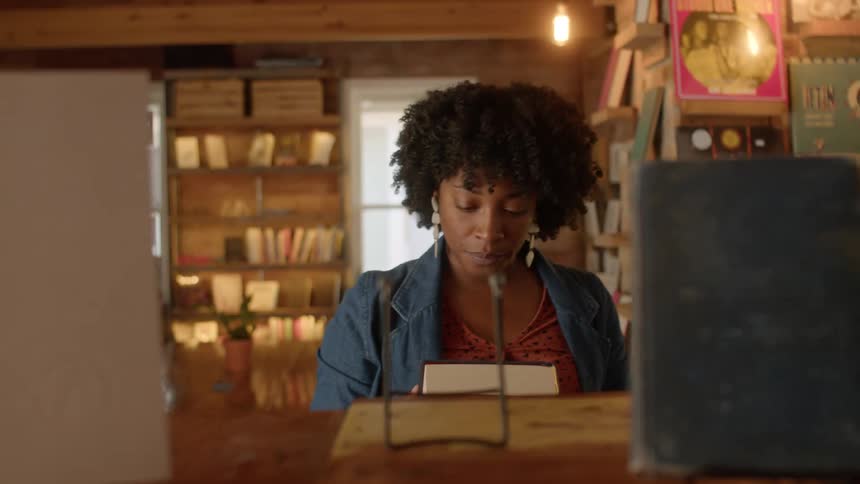 Woman picks up a book from the display and takes it with her