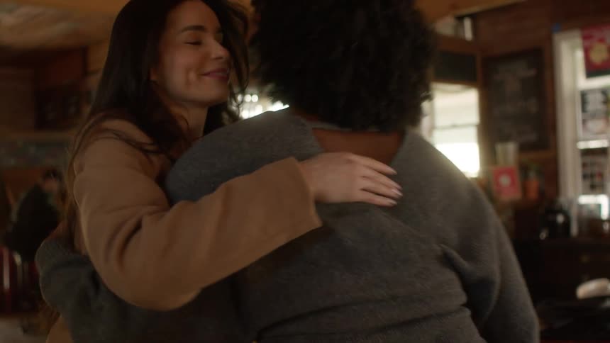 Friends greeting each other and sitting at a restaurant table