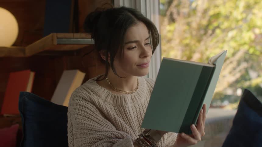 Woman reading a book in a bookstore