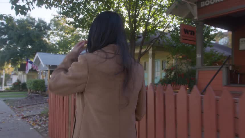 Woman walks to a coffee shop in the neighborhood