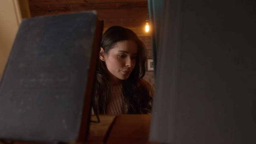 A young woman with dark hair holds a book while in a bookstore