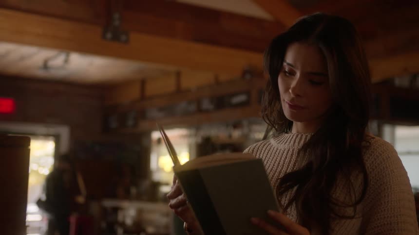 Woman finds a book in the coffee shop
