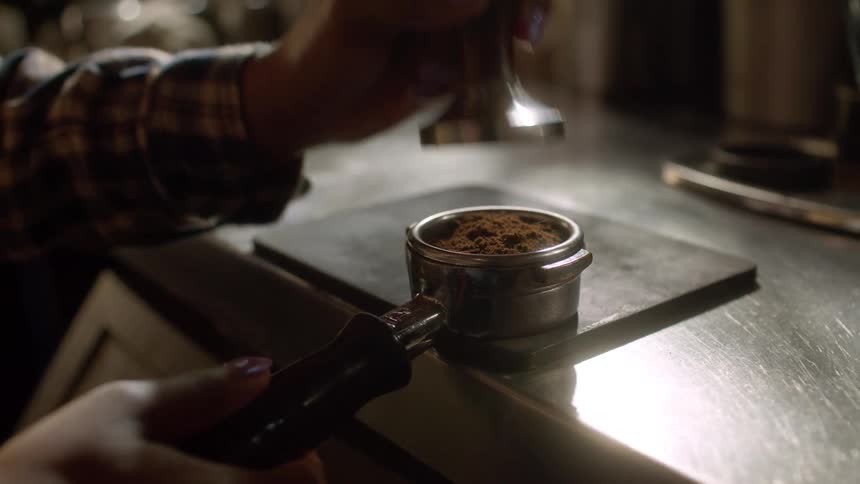 Barista presses coffee on an espresso filter