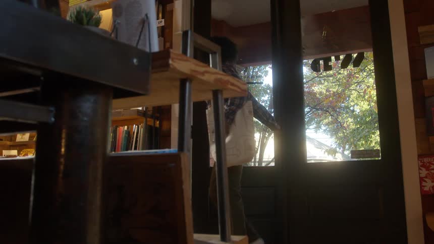 Woman walks through doors into bookstore