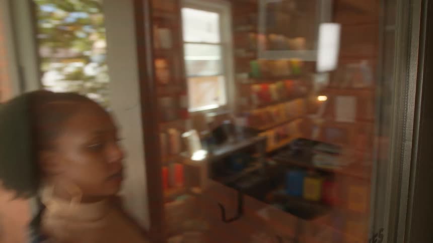 Woman opens the door to enter a coffee shop