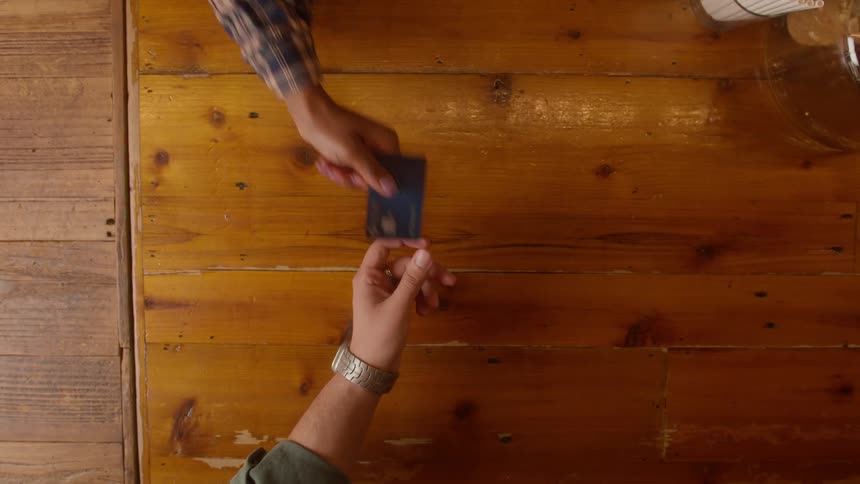 Male customer hands his credit card to server to pay