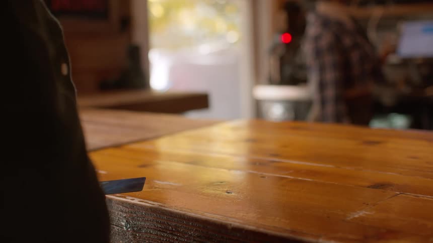 A person holding out a card to another person behind a table