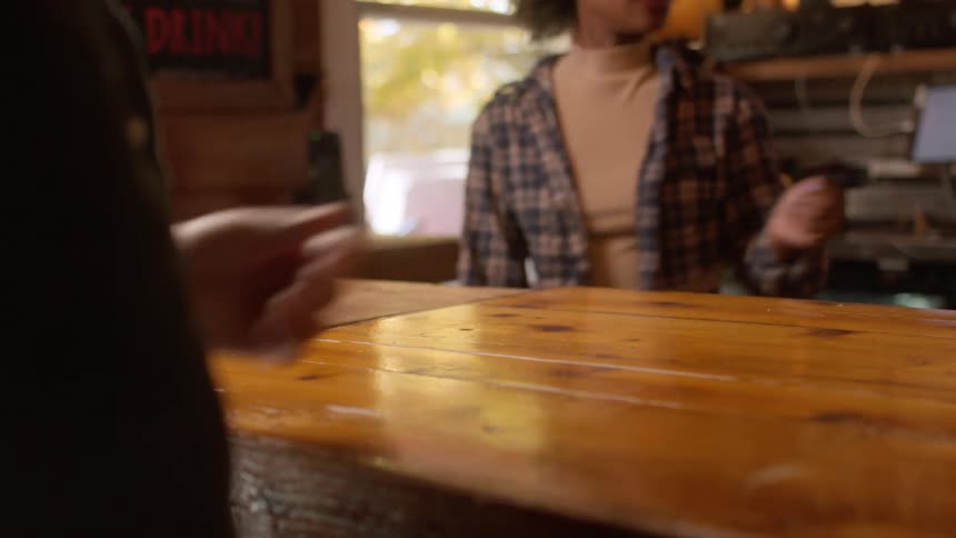 A person hands a credit card to the person working the register