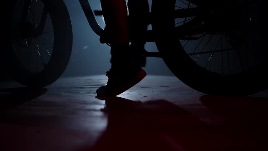 Silhouette of a person spinning the pedal on a bicycle