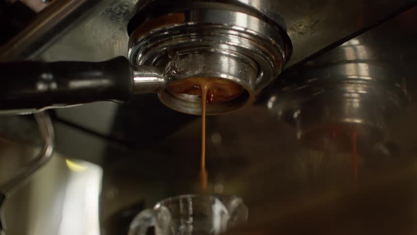 A coffee machine pouring out freshly made coffee