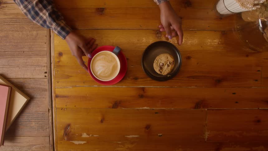Employee serves coffee and cookie to a customer