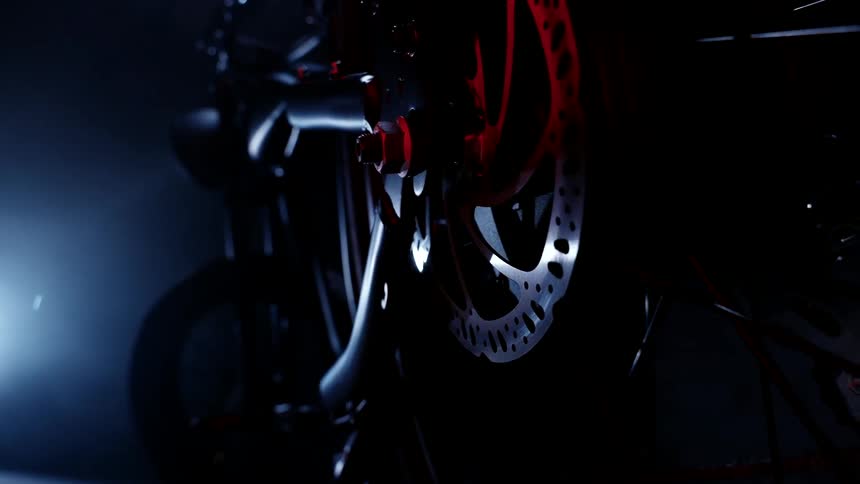 Light shining on a motorcycle wheel and gear at night